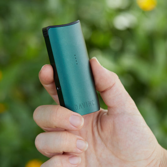 Green Miqro-C in mans hand outside.
