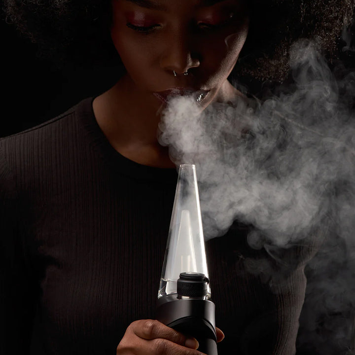 A woman using the Puffco Peak Pro.
