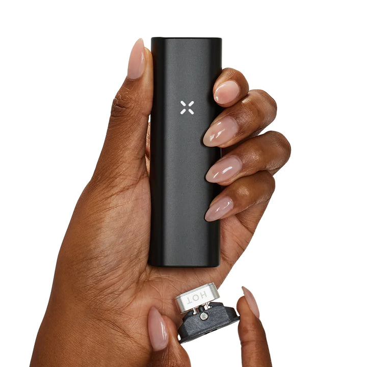 Womans hand holding Onyx Pax Plus and concentrate insert.